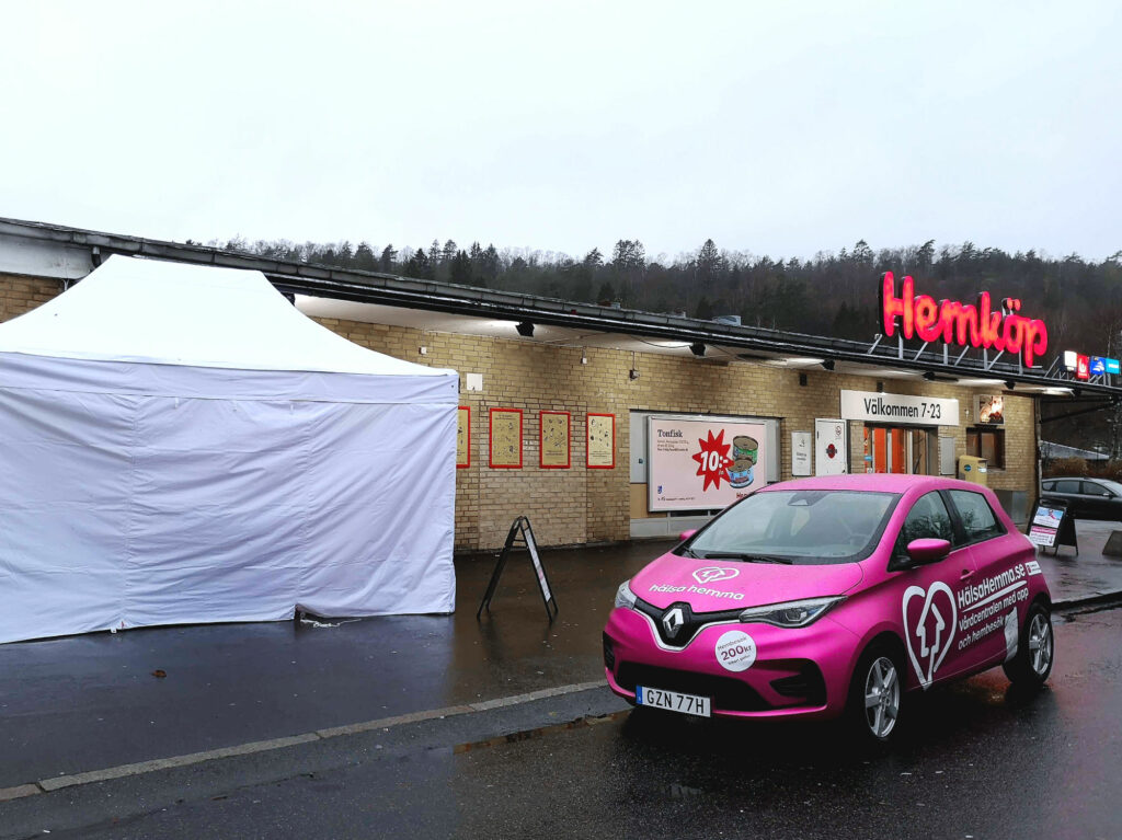 Hälsa Hemma Vårdcentrals rosa bil framför Hemköp.